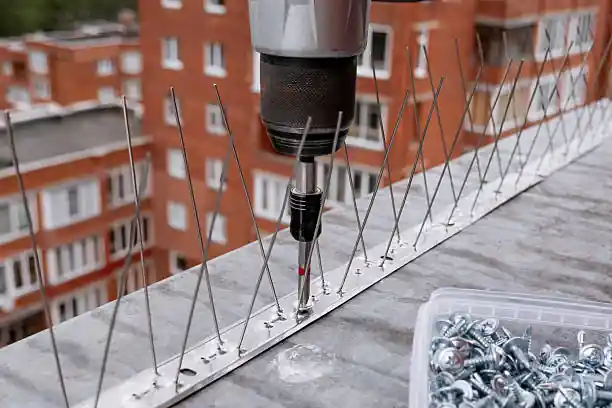 "صورة توضح فني من شركة تركيب طارد حمام أثناء تركيب الشبك على أحد المباني"